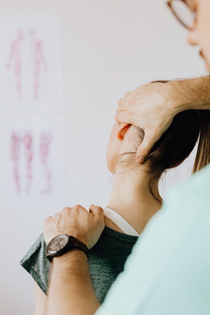 pexels-photo-4506161 A female patient receives a chiropractic neck adjustment in a medical office for pain relief.